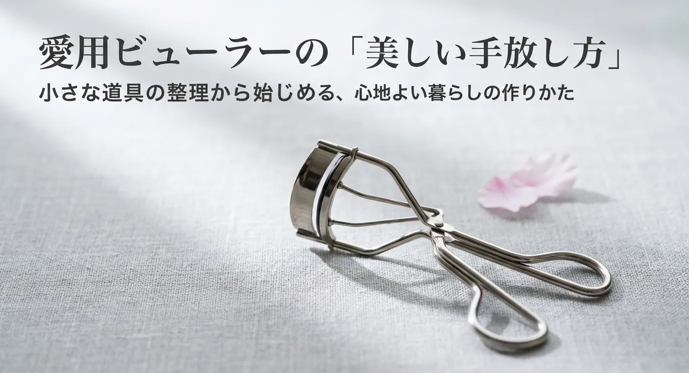 リネン生地の上に置かれた金属製のビューラーと、背景に添えられた花びらのイメージ画像。